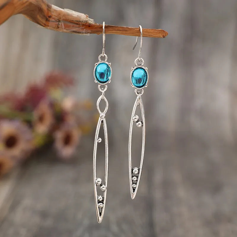 Silver drop earrings with azure stones and dangling elongated frames with bead details.