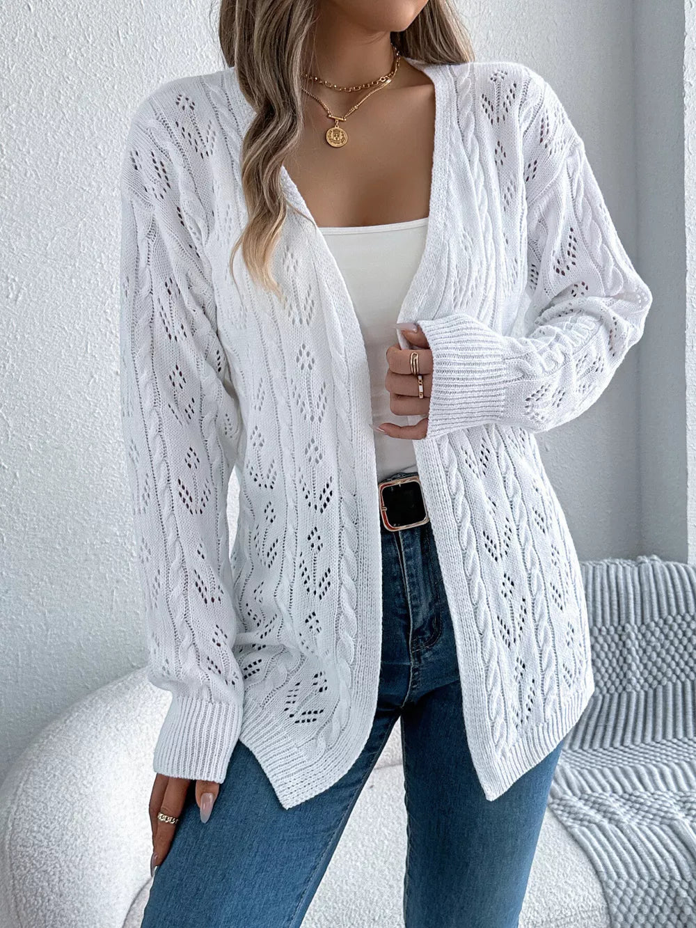 White openwork long sleeve acrylic cardigan with cable knit details.