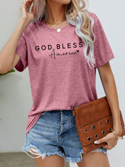 Dusty Pink God Bless America script graphic tee with crew neck and short sleeves.
