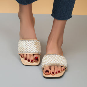 Chic open toe slides with pearl and rhinestone embellished straps and a low heel.
