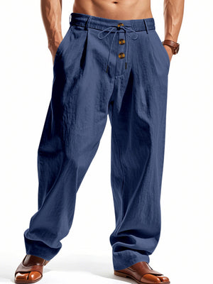 Men's navy blue drawstring loose fit pants with button detail and pleats.