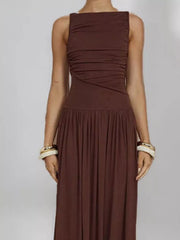 Brown ruched maxi dress with gathered neckline and full skirt.