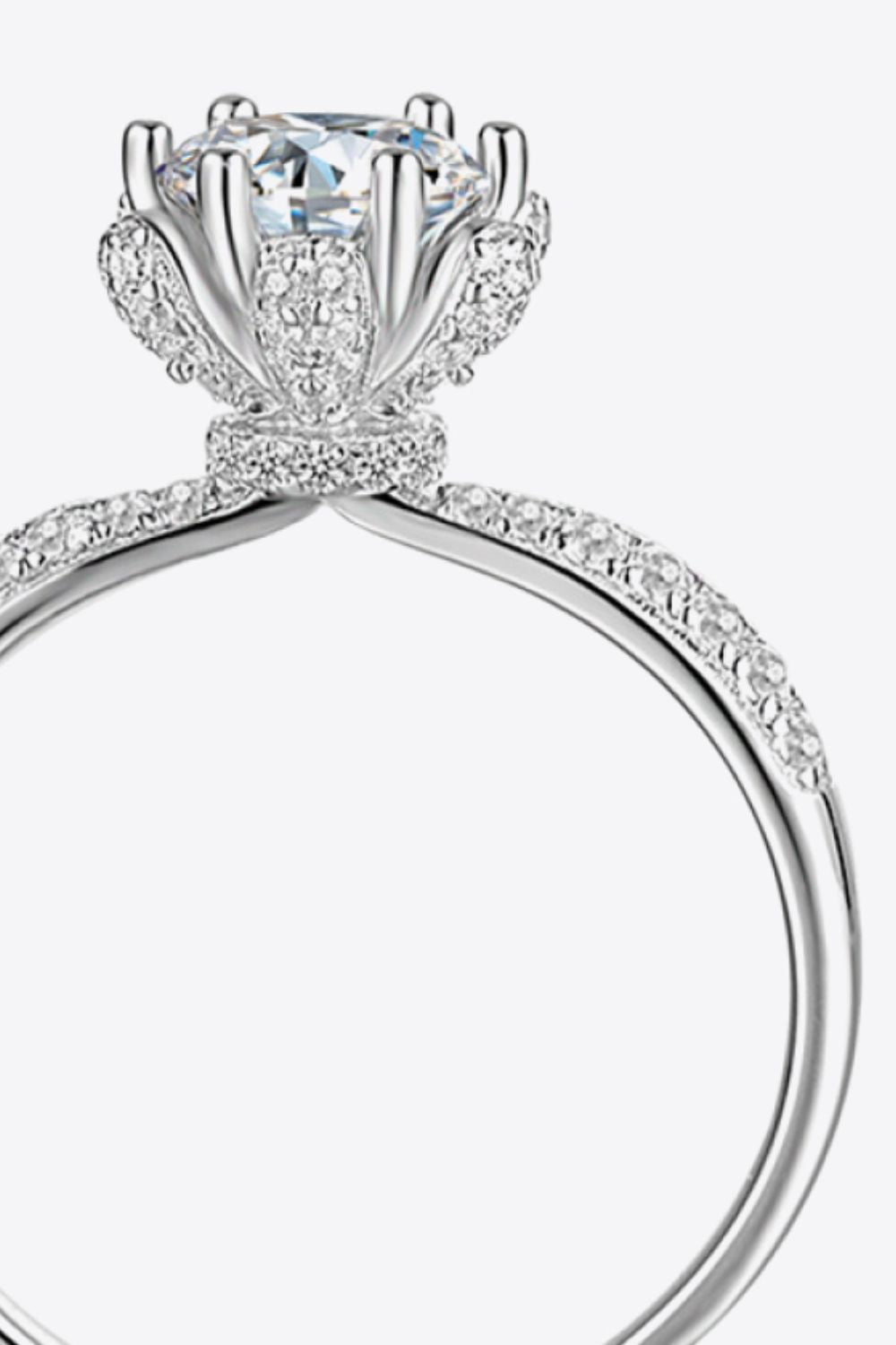 Silver halo ring with a floral-inspired moissanite center stone and diamond accents.