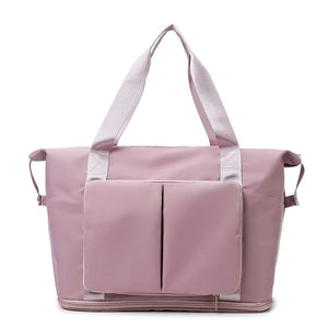 Foldable travel tote in dusty pink with exterior pockets and dual top handles.