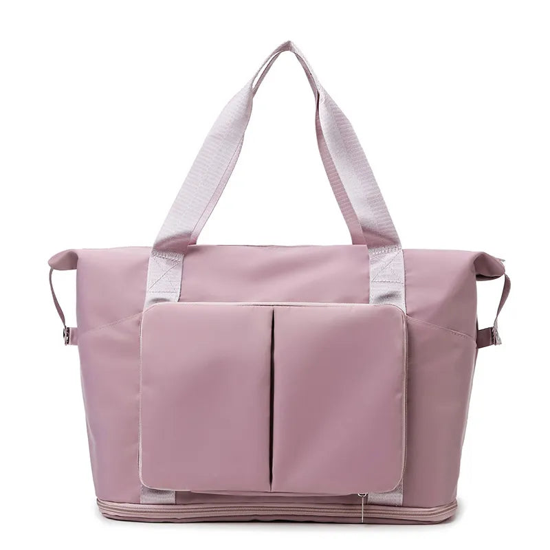 Foldable travel tote in dusty pink with exterior pockets and dual top handles.