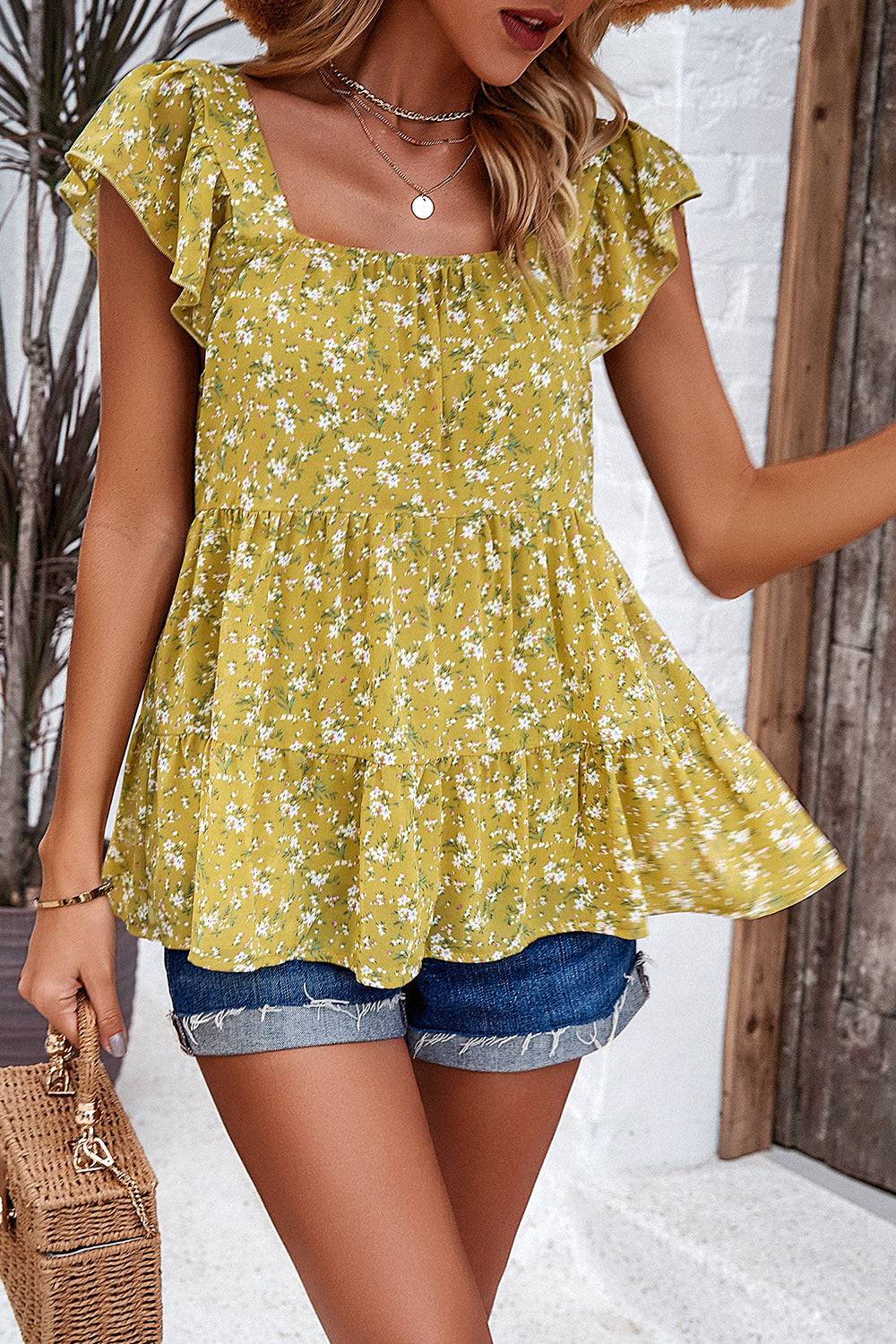 Chartreuse floral peplum blouse with flutter sleeves and tiered hem.
