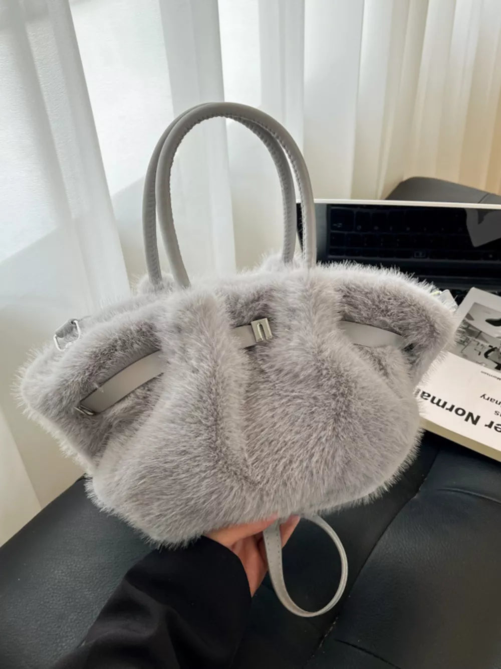 Plush gray crossbody bag with chic buckle and leather trim.