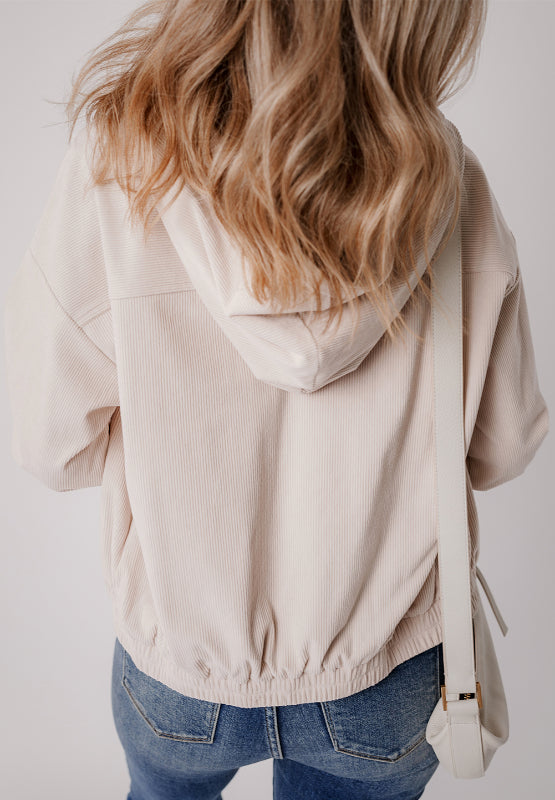 Cream corduroy bomber hoodie with drawstring hem and hood, relaxed fit.