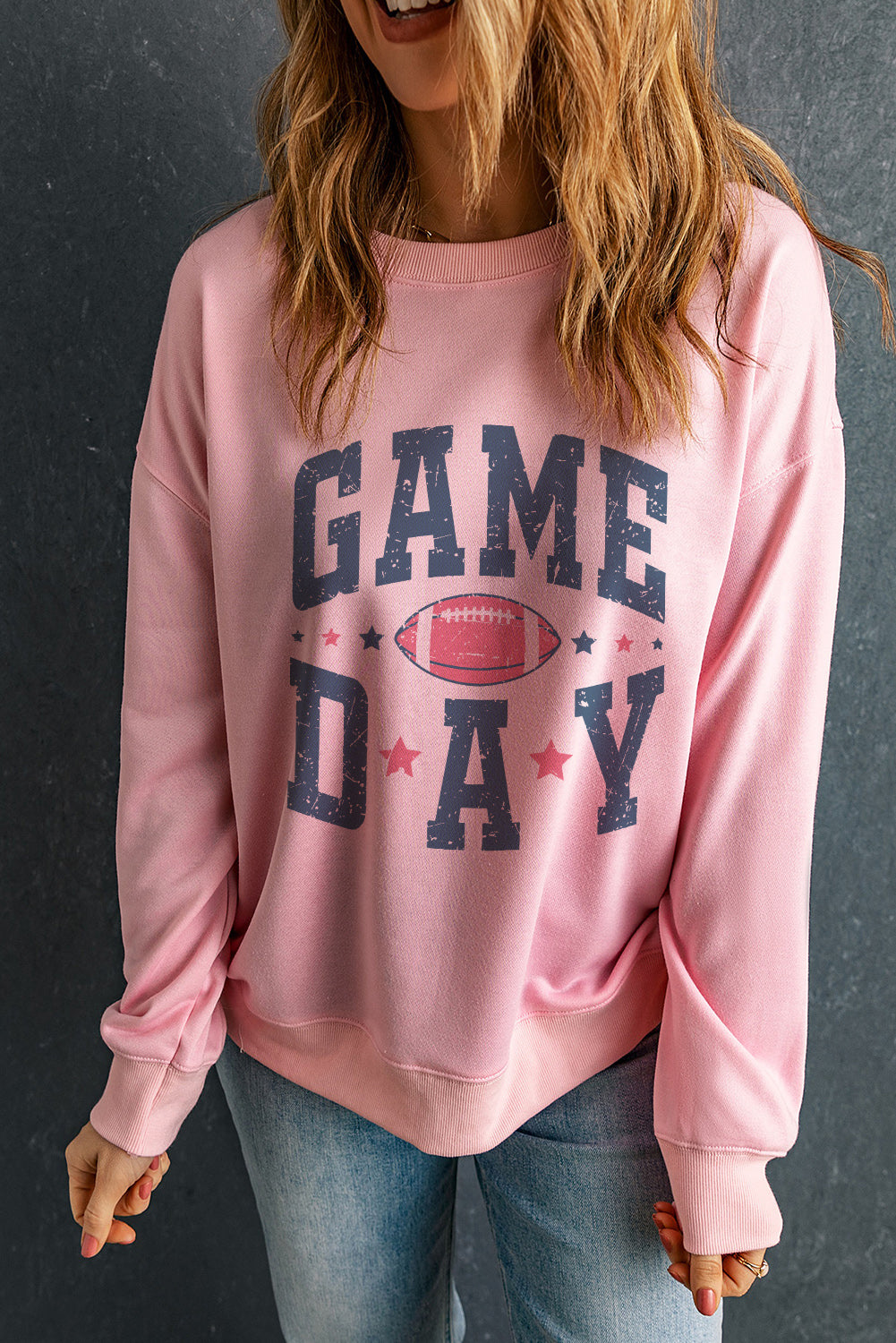 Game Day graphic crewneck sweatshirt in blush pink with football and stars design.