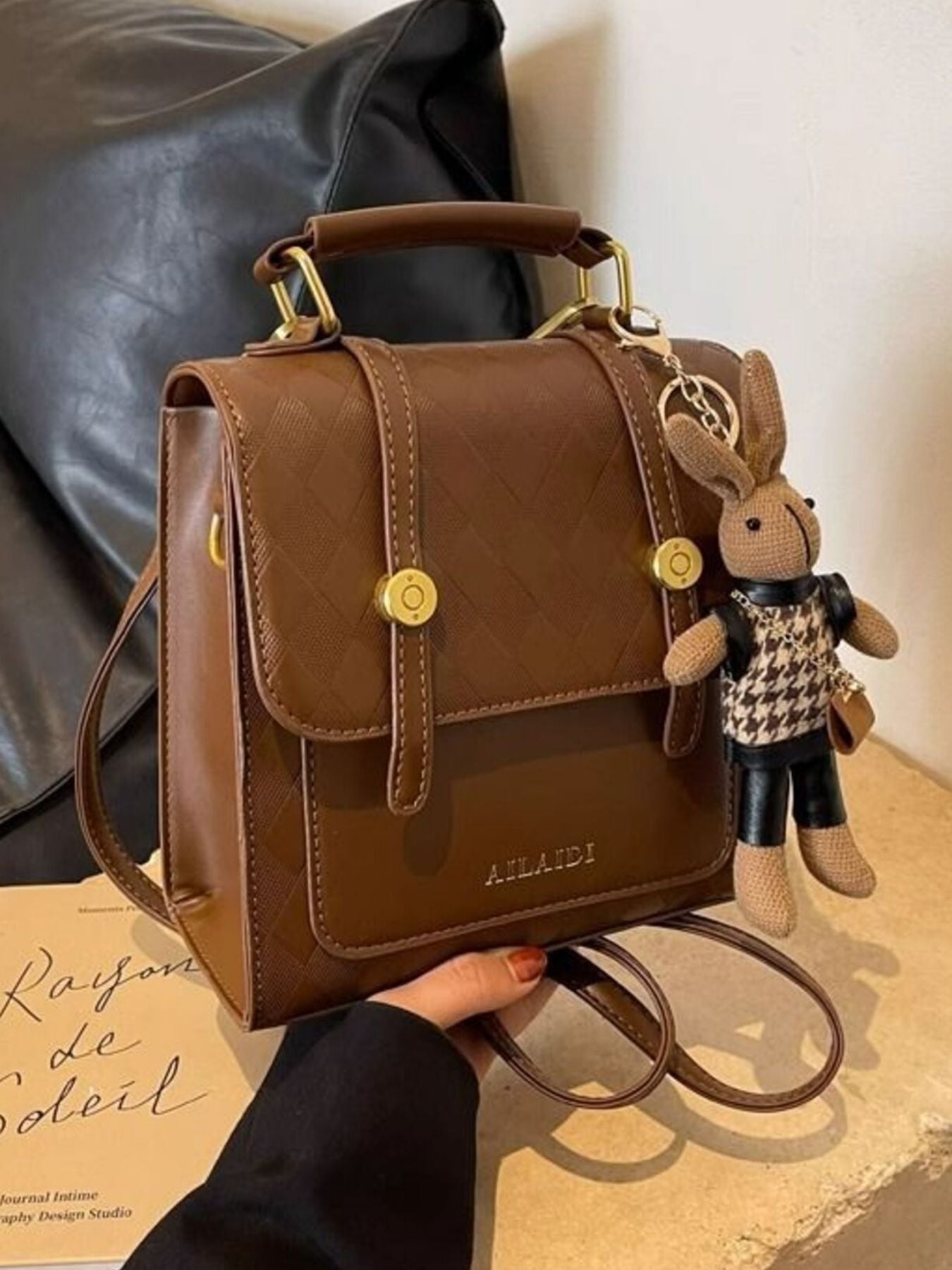 Brown quilted flap mini backpack with gold hardware and bunny charm