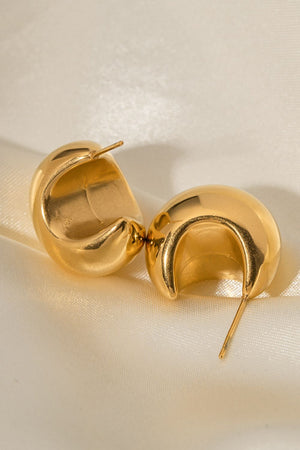 Gold sculptural crescent hoop earrings with a polished finish.