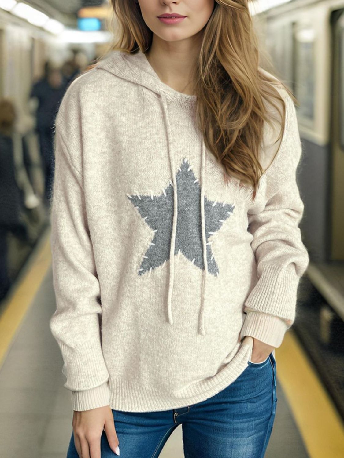 Beige knit hoodie with gray textured star appliqué and drawstring hood.