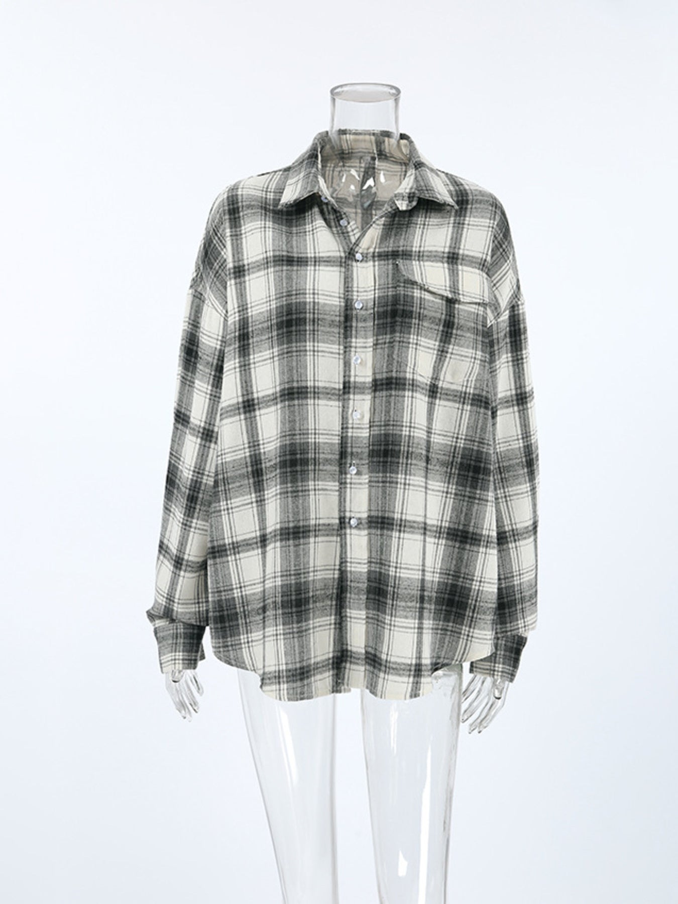Button-up long sleeve cotton shirt in black and white plaid with a collar and chest pocket.