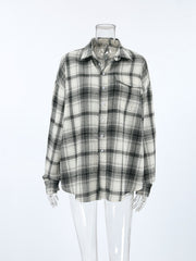 Button-up long sleeve cotton shirt in black and white plaid with a collar and chest pocket.