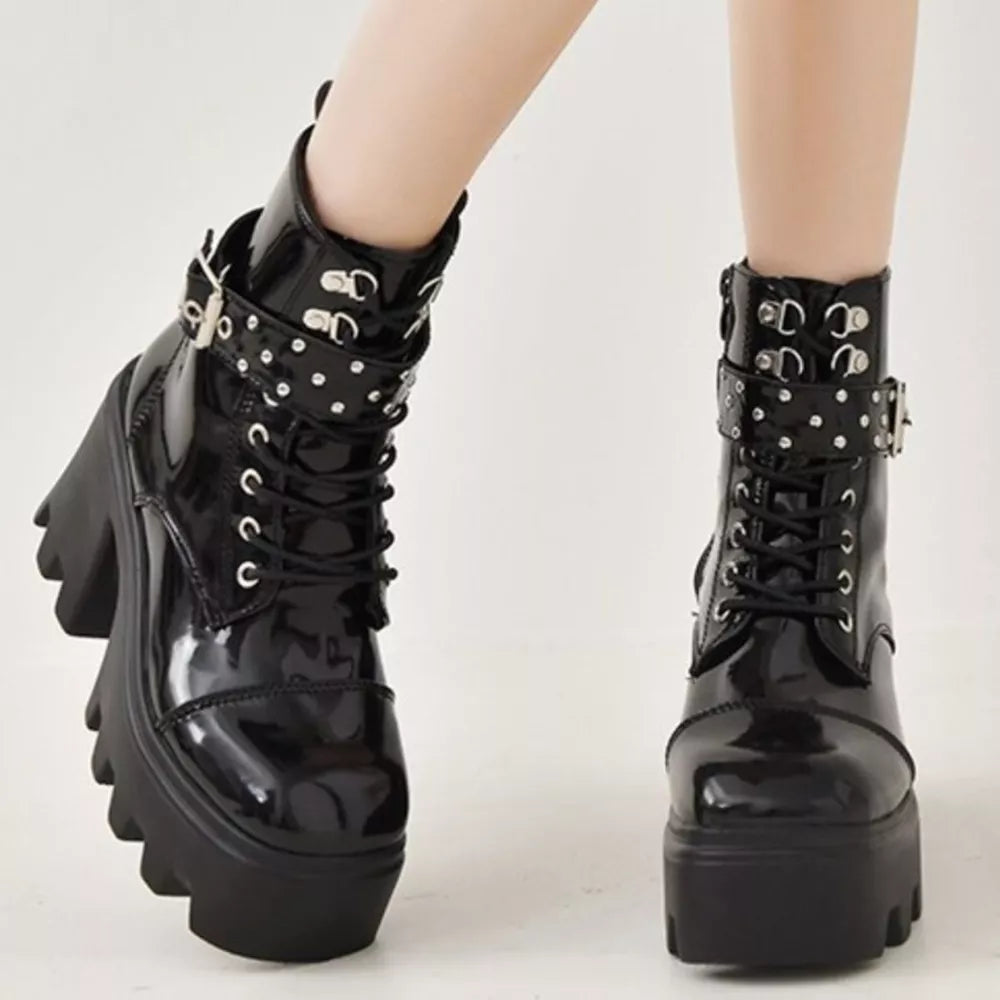 Black glossy platform ankle boots with buckle accents and studded straps.