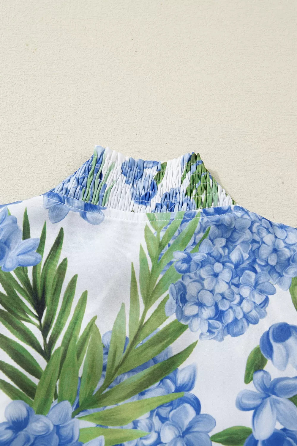 Blouse with blue hydrangea floral print and smocked neckline detail