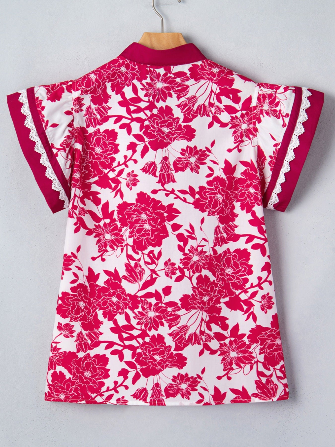 White polyester blouse with a bold pink floral print, lace trim on sleeves, and a stand collar.