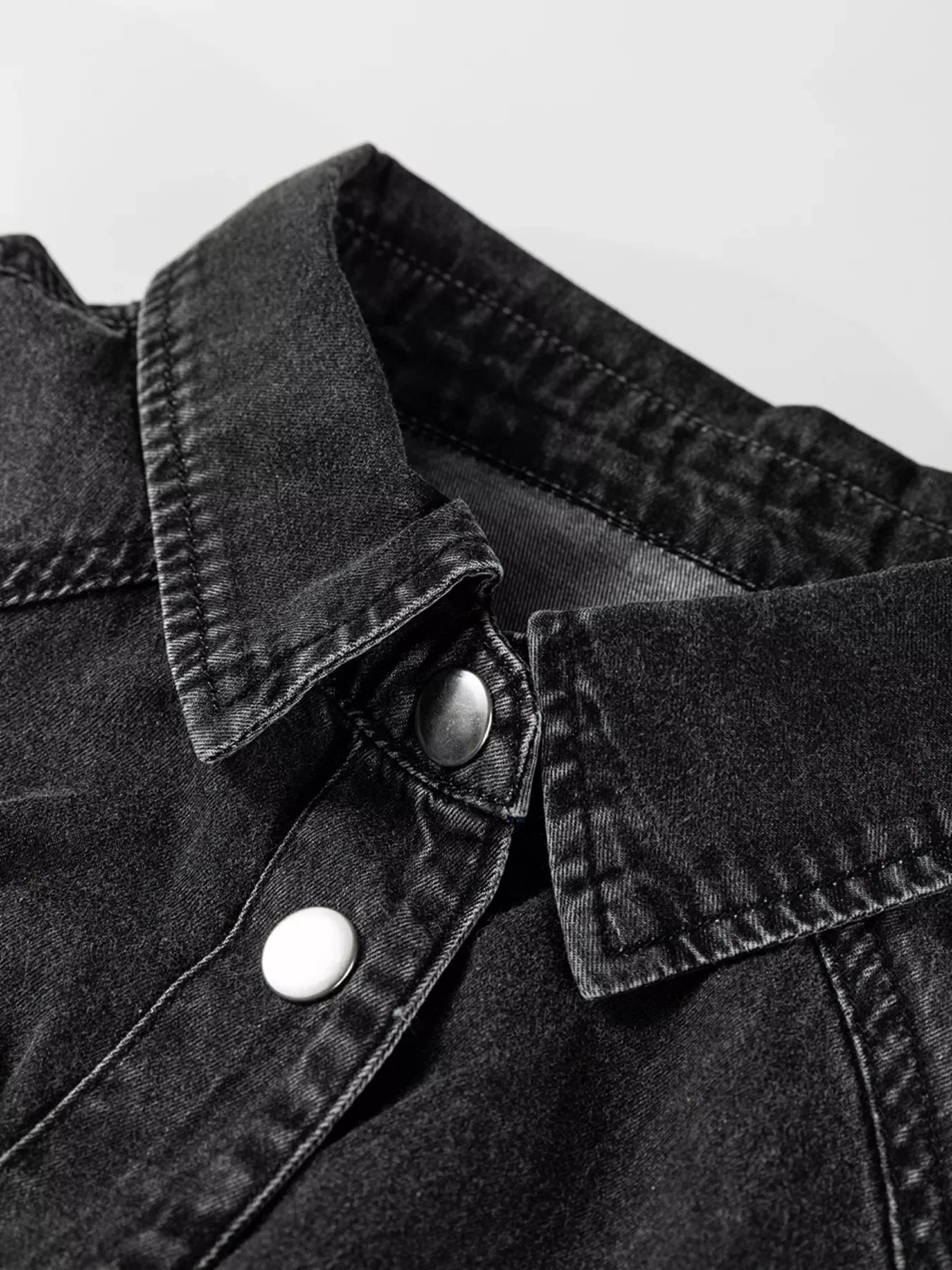 Black denim button-up dress with a collared neckline and silver snap buttons.