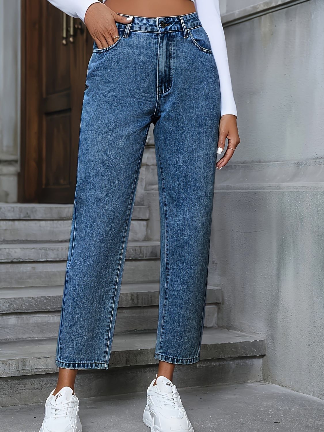 Medium wash high-rise denim jeans with a straight leg and button fly.
