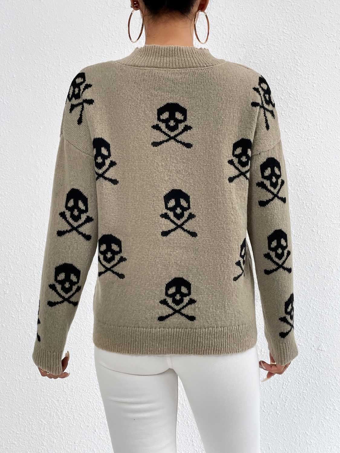Khaki drop shoulder knit sweater with all-over black skull and crossbones pattern.
