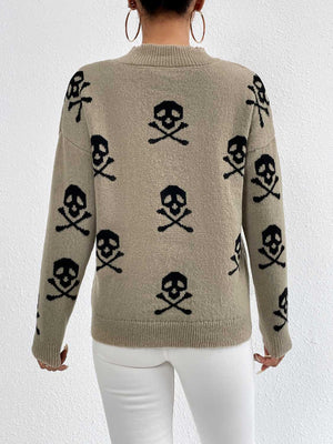 Khaki drop shoulder knit sweater with all-over black skull and crossbones pattern.