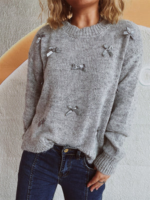Gray knit crewneck sweater with scattered silver bow embellishments.