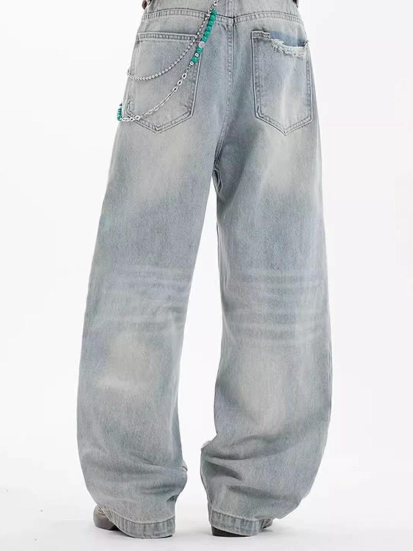Washed cotton wide-leg men's jeans in light blue with distressed details and chain accessory.