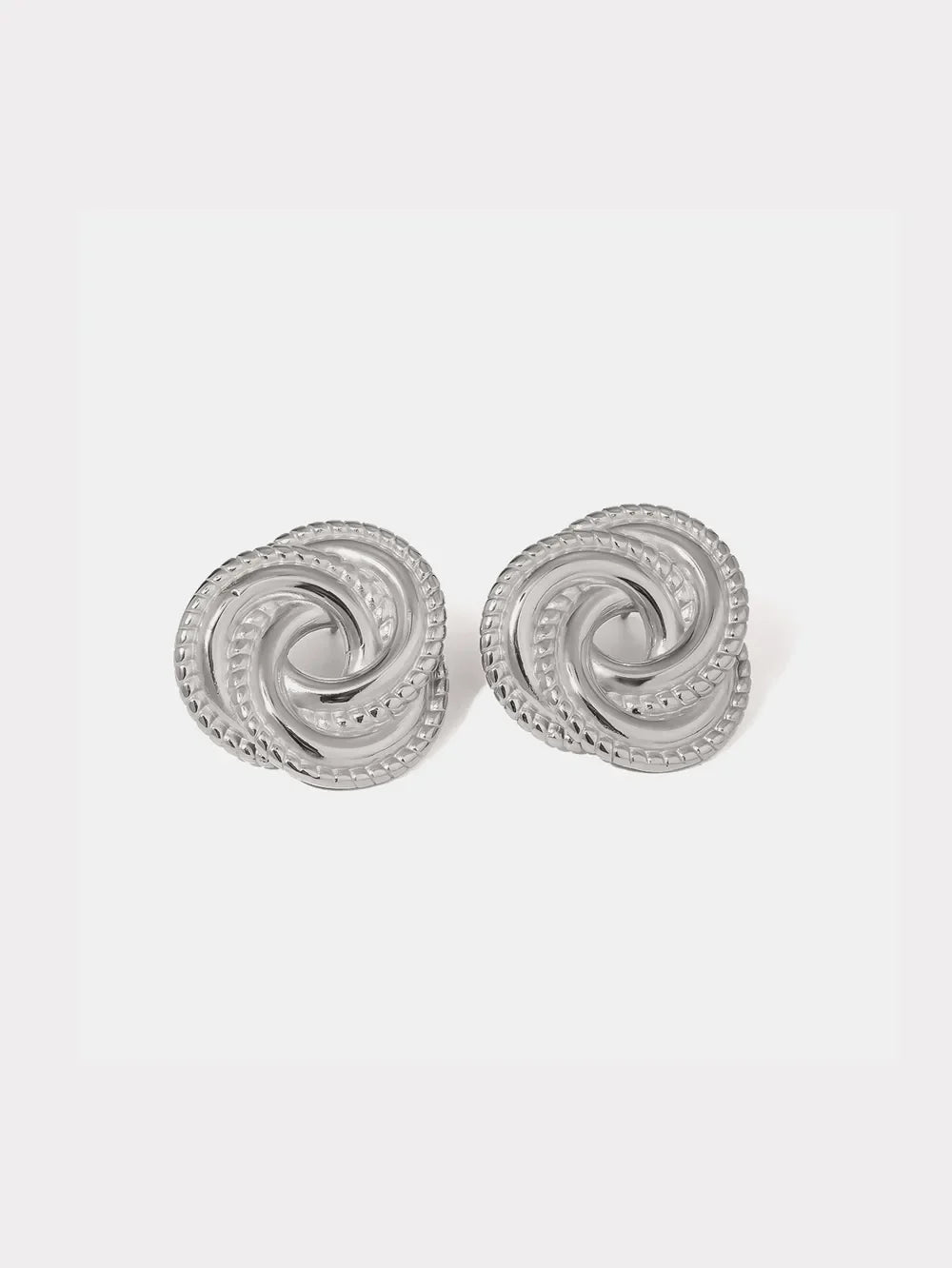Silver swirl knot stud earrings with textured rope edge detail