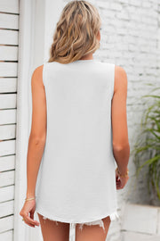 White textured sleeveless blouse with a rounded hem and frayed shorts.