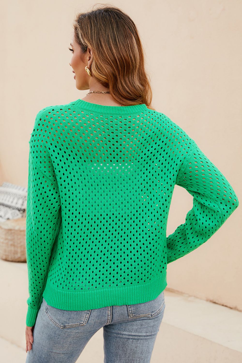 Green open-knit crewneck sweater with subtle texture and long sleeves.