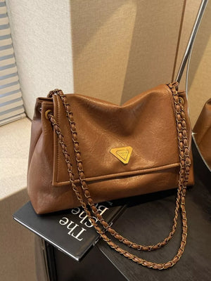 Brown leather shoulder bag with flap and chain detail.