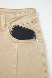 High-waisted cropped wide-leg jeans in tan denim with a phone in the pocket.