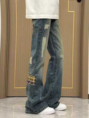 Distressed blue wash wide-leg jeans with patchwork detail and 100% cotton fabric.
