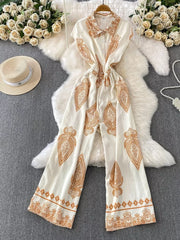 White button-down wide leg romper with ornate brown paisley print and collared neckline.