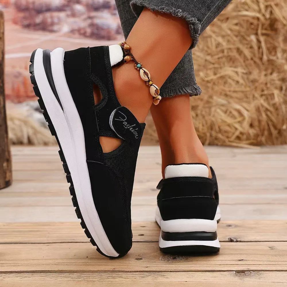 Black cutout mesh platform slip-on sneakers with white accents and "Fashion" detail.