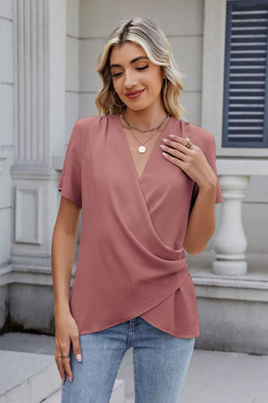 Dusty pink short sleeve blouse with draped crossover neckline and textured fabric