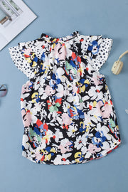 Dalmatian Trim Floral Print Blouse with ruffled neckline and flutter sleeves.