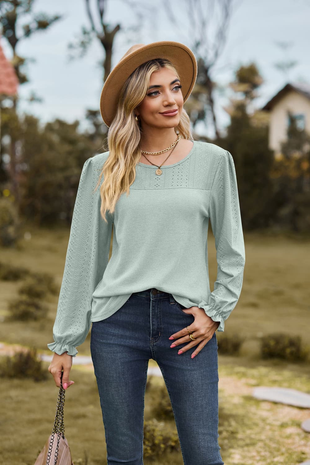 Sage perforated waffle knit blouse with ruffled cuffs and puff sleeves.