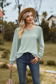 Sage perforated waffle knit blouse with ruffled cuffs and puff sleeves.