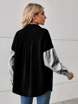 Black denim overshirt with leopard print sleeves and button front.