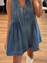 Light blue denim playsuit with V-neck, tie front, and pleated details.