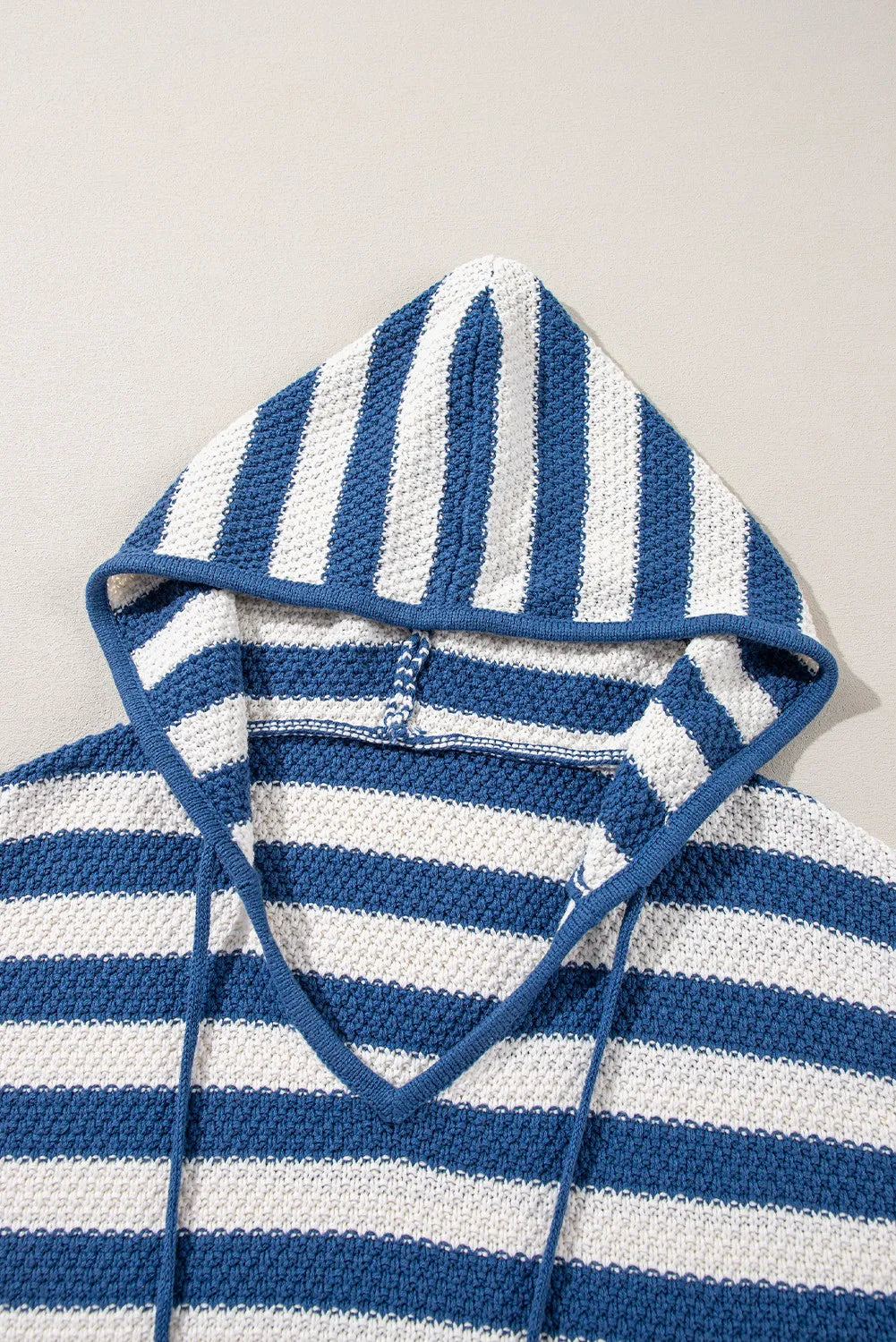 Textured stripe knit hoodie in peacock blue and white with adjustable drawstring hood and pouch pocket.
