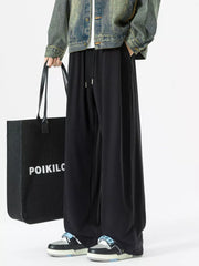 Black relaxed fit drawstring sweatpants with pockets and a wide leg.