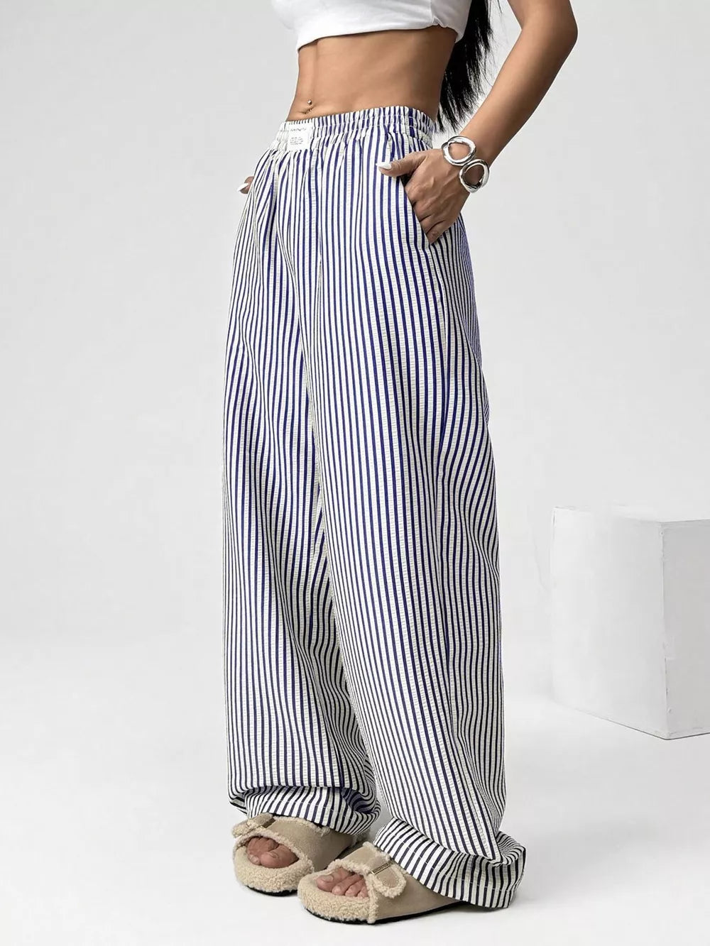 Navy striped high-waisted wide-leg pants with drawstring detail and pockets.