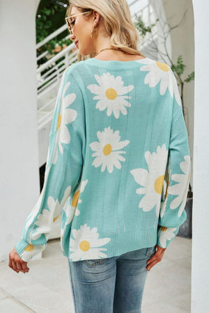 Light blue intarsia knit sweater with white daisy pattern, crew neck, long sleeves.