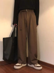Brown wide-leg sweatpants with belt and D-ring detail, styled casually.