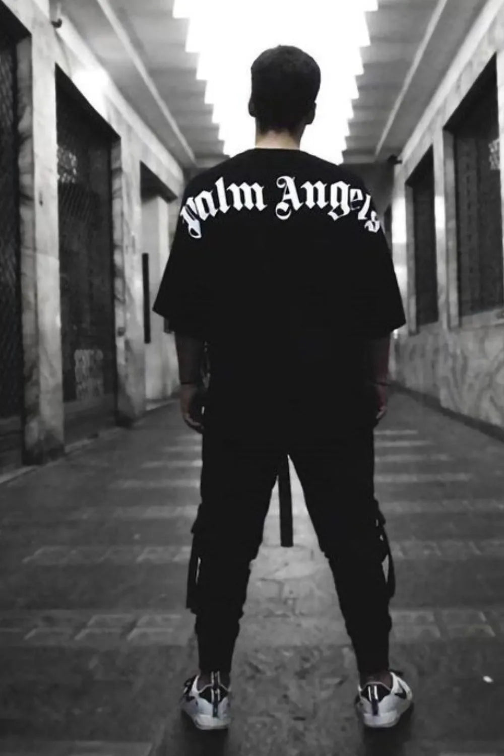 Black oversized tee with white gothic script back print, crew neck, short sleeves.