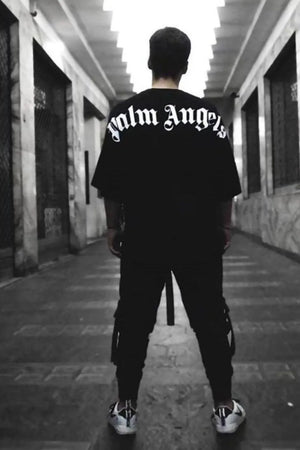 Black oversized tee with white gothic script back print, crew neck, short sleeves.