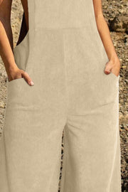 Corduroy overalls in tan with wide legs and front pockets.