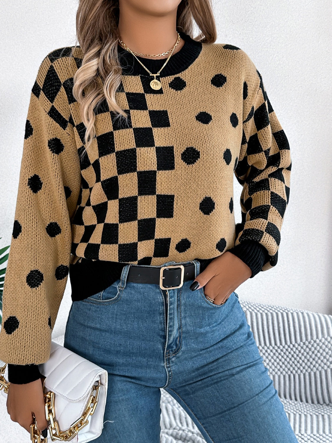 Camel checkerboard and dot intarsia knit sweater with black trim and crewneck.